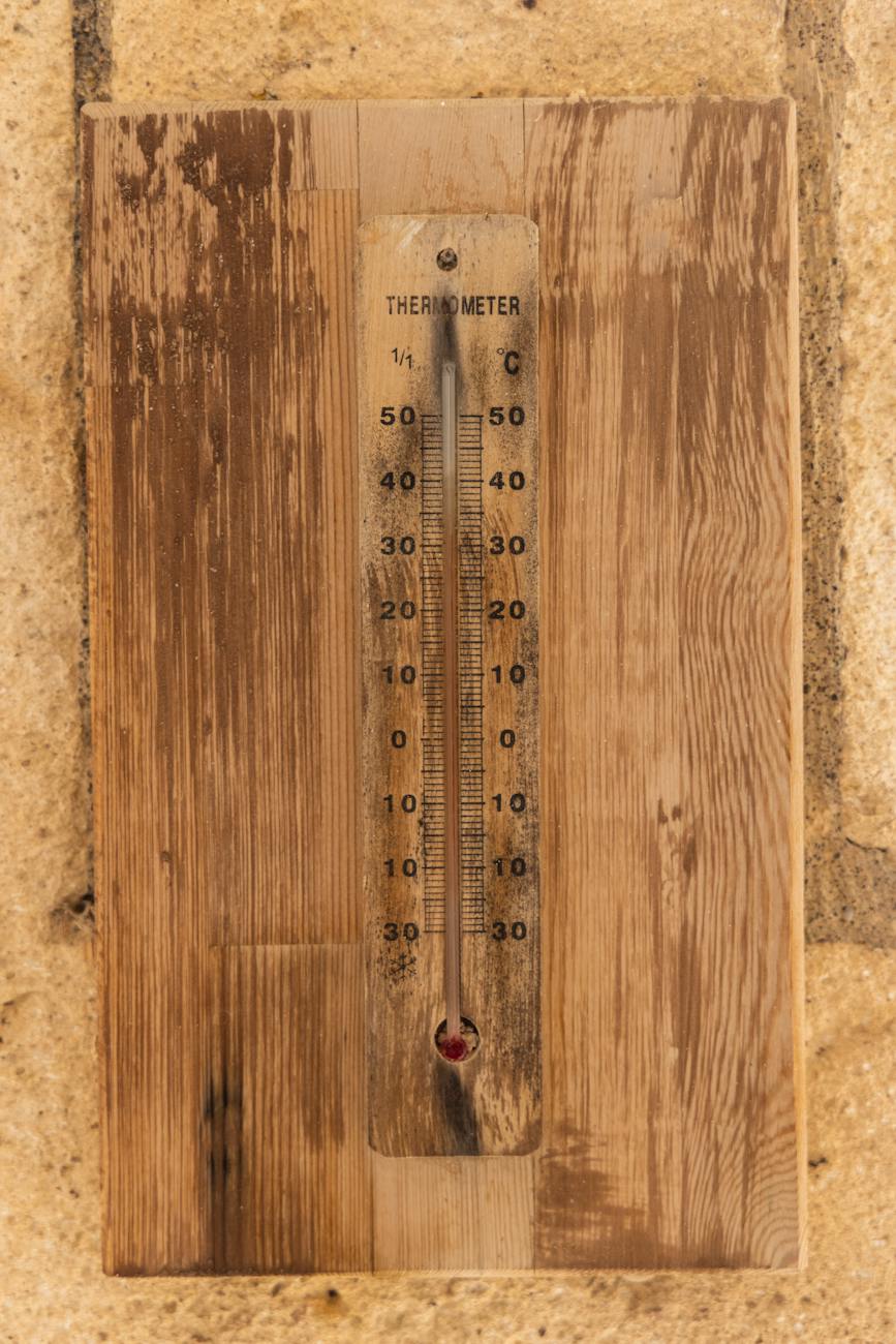 brown wooden wall thermometer on the wall